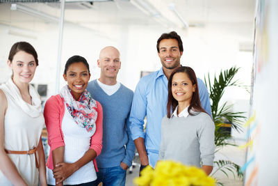 Portrait of smiling friends standing at home