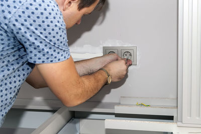 Midsection of man photographing at home