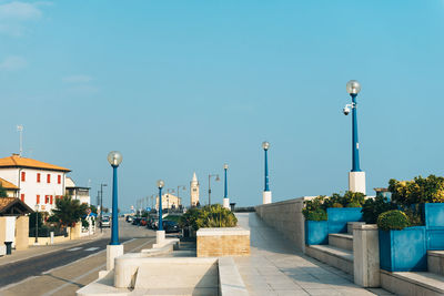 Street amidst buildings against clear blue sky