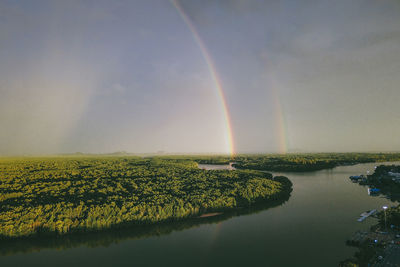 Scenic view of rainbow over lake against sky