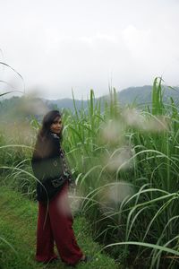 Woman standing on field against sky