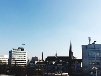 Buildings in city against blue sky