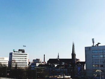 Buildings in city against clear sky