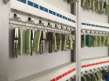 Close-up of safety keys hanging in row inside metal rack