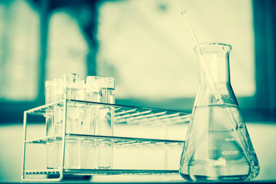 Close-up of beaker with test tubes on table in laboratory