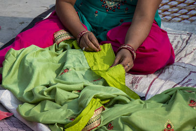 High angle view of woman sitting on sidewalk