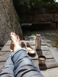 Low section of man relaxing by tree