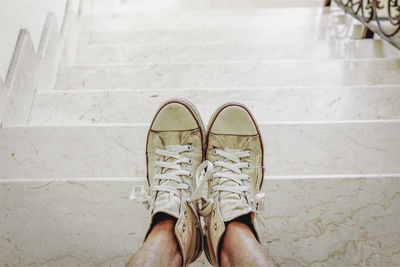 Low section of man standing on staircase