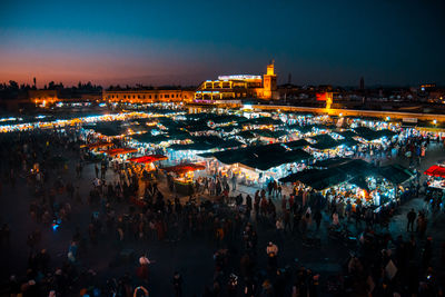 High angle view of crowd at illuminated market during night