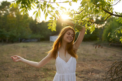 Portrait of smiling young woman standing in park