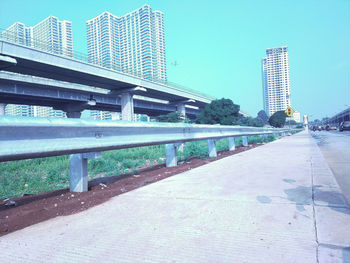 Bridge by buildings against sky in city