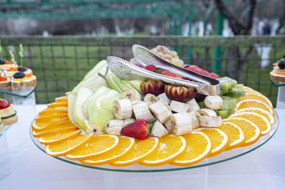 Various fruits in plate on table