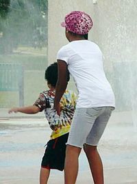 Rear view of couple standing against the water