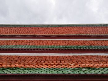 Low angle view of roof tiles against sky