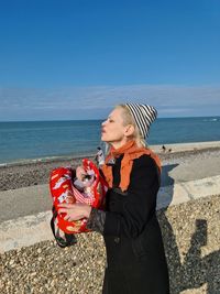 Senior woman on beach against sky