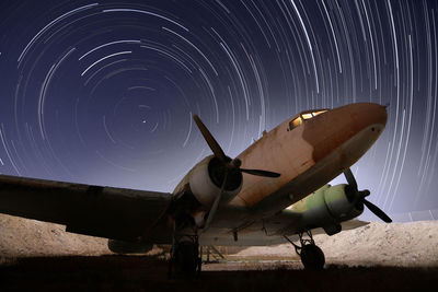 Low angle view of airplane against clear sky at night