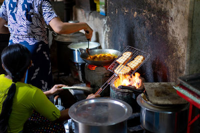 People preparing food on barbecue grill