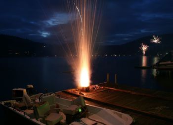 High angle view of firework exploding on pier at night