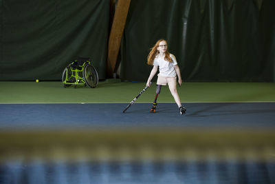 Girl with artificial leg playing tennis