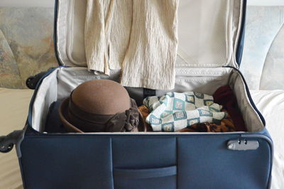 Close-up of hat and fabrics in luggage