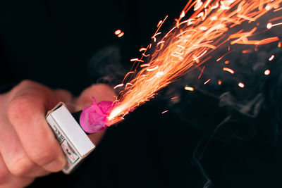 Close-up of hand holding lit candles