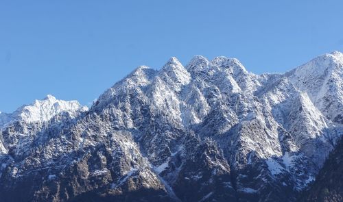 Low angle view of snow covered mountain against clear sky