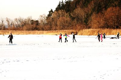 People walking on snow covered trees