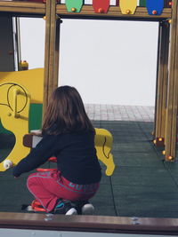 Rear view of girl playing at playground