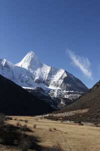 Scenic view of snowcapped mountains against blue sky