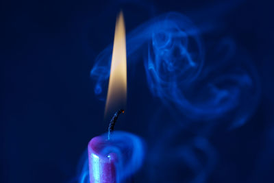 Close-up of hand holding burning candle