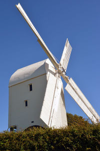 Low angle view of traditional windmill against clear blue sky