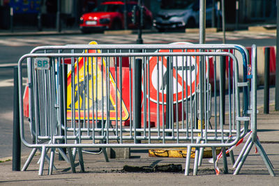 Empty chairs on sidewalk in city