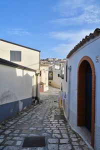 A narrow street between the old houses of grottole, a village in the basilicata region, italy.