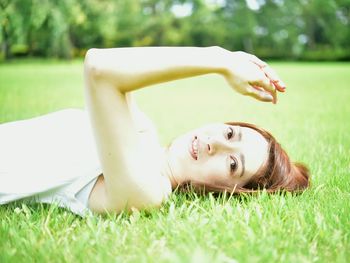 Young woman lying on grassy field