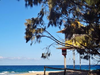 Scenic view of lookout tower on beach against cloudy sky