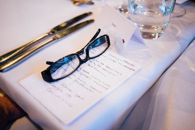 Close-up of eyeglasses by note on table