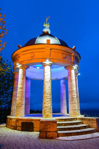 Low angle view of illuminated building against blue sky