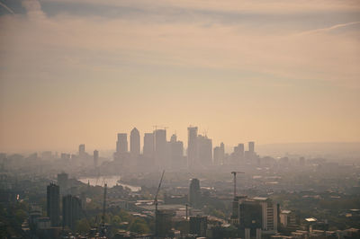 Modern buildings in city against sky during sunset