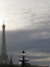 Statue in city against sky