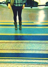 Low section of woman standing on tiled floor