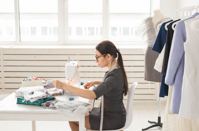 Side view of a woman working on table