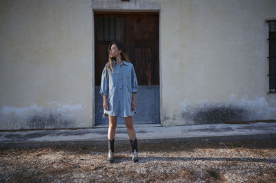 Full length of woman standing against building