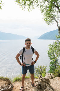 Full length portrait of young man standing on mountain