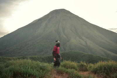 Rear view of man walking on mountain road