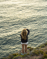 Rear view of woman standing in sea