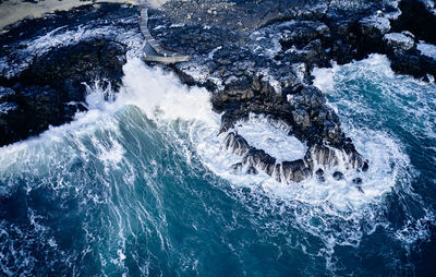 Waves crashing over coastline in sea