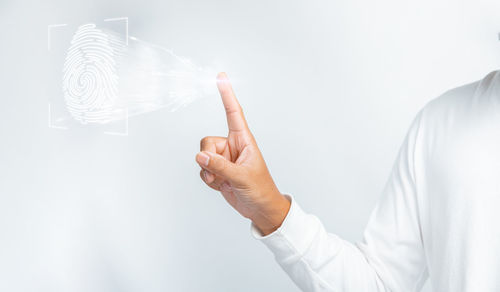 Midsection of man holding sparkler against white background