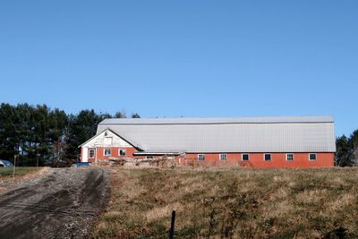 Built structure on field against clear blue sky