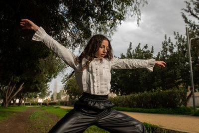 Full length of young woman exercising in park