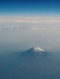 Snow covered mountain peak against blue sky